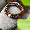 Conjunto de duas pulseiras feitas com pedras olho de tigre vermelho e castanho com separadores dourados inoxidáveis
